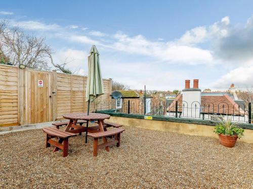 een picknicktafel en een parasol naast een hek bij Vine Cottage in Broadstairs