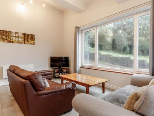 a living room with a couch and a table at The Barn-Uk32860 in Alltwen