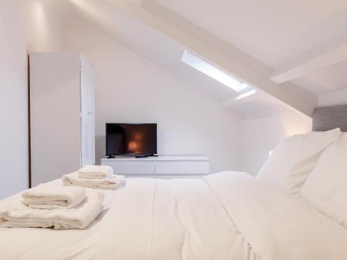 a white bedroom with a bed and a tv at The Barn-Uk32860 in Alltwen