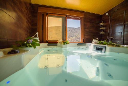 a large bath tub in a bathroom with a window at Casa Al Revés in Laroya