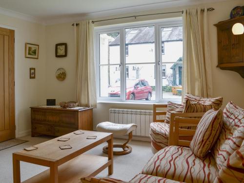 a living room with a couch and a table at Meadowcroft Cottage in Bowness-on-Windermere