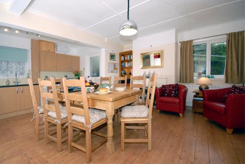 a kitchen and living room with a wooden table and chairs at Seascape in New Quay