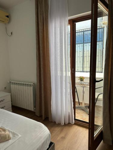 a bedroom with a bed and a sliding glass door at Rooms Ajllin in Ulcinj