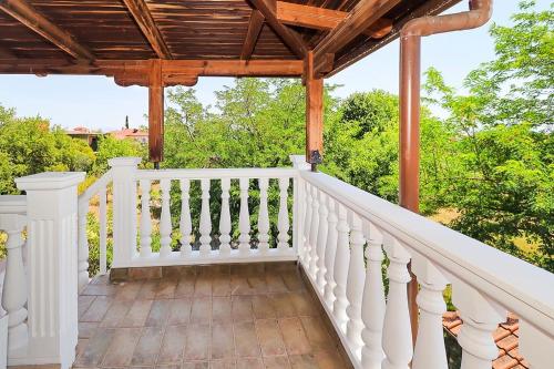 a porch with a white railing and a wooden pergola at Makrygialos-Atlantis in Makrýgialos