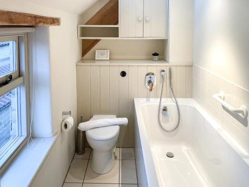 a bathroom with a toilet and a bath tub at The Cart House in Helmsley