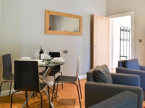 a living room with a table and chairs and a mirror at Beckside House in Dalton in Furness