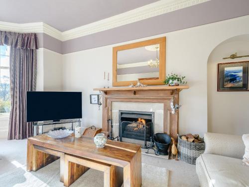 a living room with a tv and a fireplace at The Bield in Aberfoyle