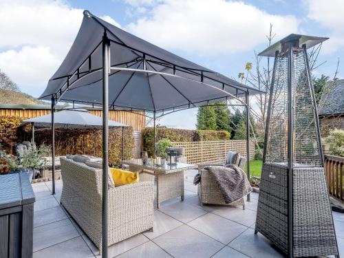 an umbrella on a patio with a table and chairs at The Bield in Aberfoyle