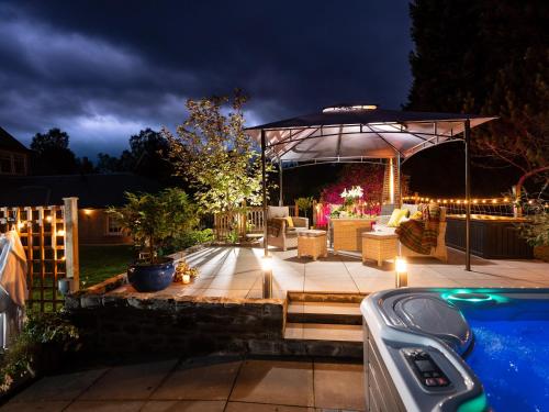 a backyard with a pool and a pavilion at night at The Bield in Aberfoyle