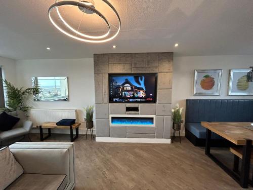 a living room with a tv and a fireplace at Seaview House in Thornton