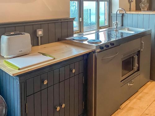 a kitchen with a sink and a stove at Southfield Workshop in Braunston