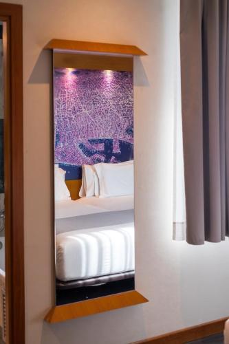 a mirror in a room with a bed at Abba Sants in Barcelona