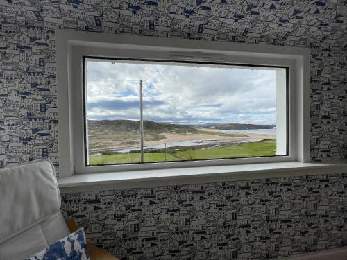 a window in a room with a view of a beach at Dalcharn in Bettyhill