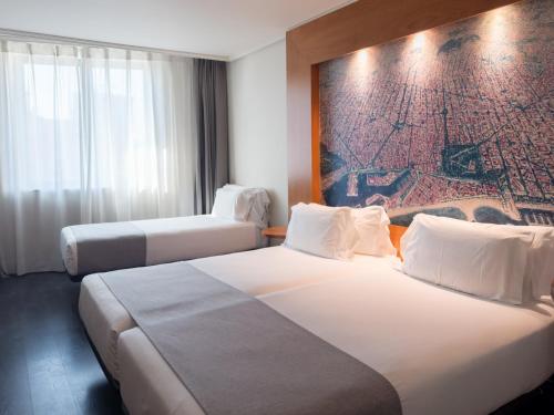 two beds in a hotel room with a painting on the wall at Abba Sants in Barcelona