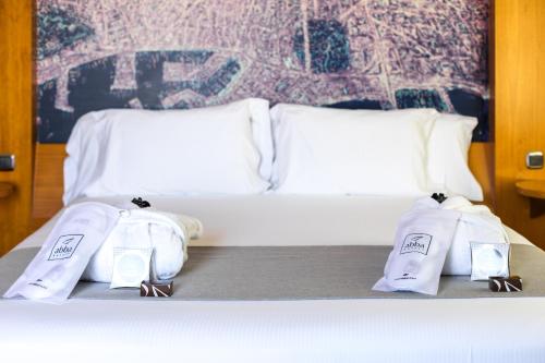 a bed with white sheets and towels on it at Abba Sants in Barcelona