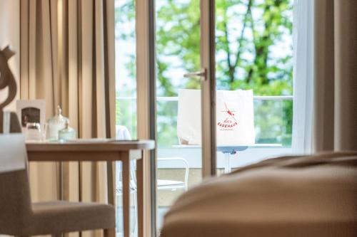 a room with a window and a table and a chair at Seehotel am Kaiserstrand in Lochau