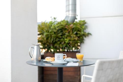 a table with a coffee pot and orange juice on it at Abba Sants in Barcelona