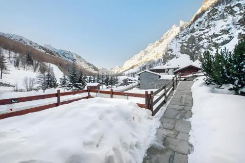 a fence covered in snow next to a mountain at Arthemisia - Rhêmes-Notre-Dame in Rhêmes-Notre-Dame