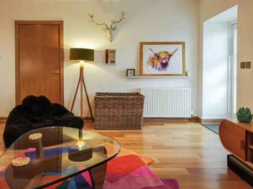 a living room with a glass table and a couch at Kilbowie Retreat in Oban