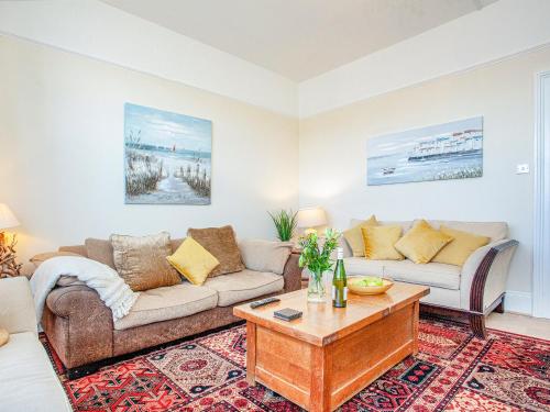 a living room with a couch and a table at The Coach House At Vane Hill in Torquay