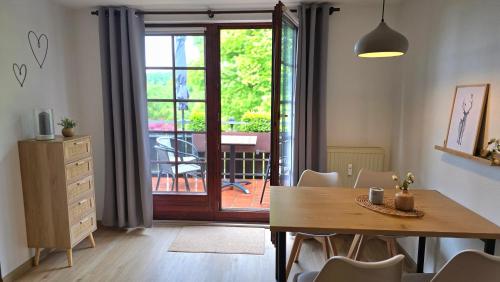 a dining room with a table and a sliding glass door at Waldliebe in Bad Sachsa