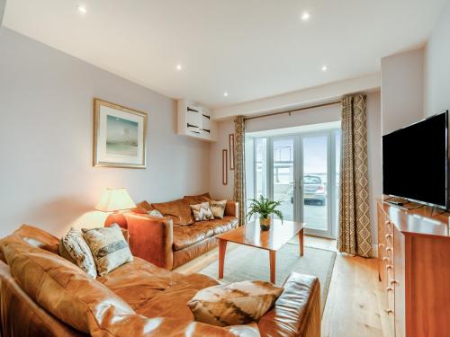 a living room with a couch and a tv at Point House in Milford Haven