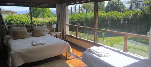 une chambre avec deux lits et une grande fenêtre dans l'établissement Azkorri Beach House, à Getxo