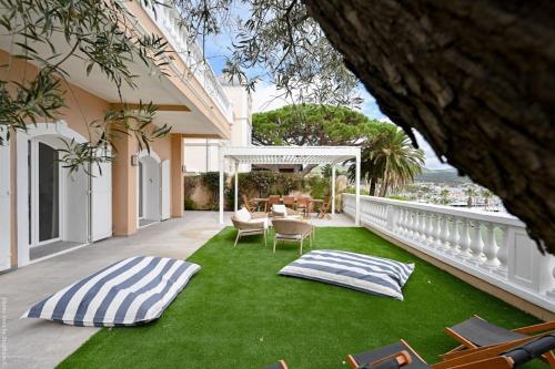 a balcony with a lawn with chairs and a table at Jonaxel - Sur le port de Bandol in Bandol
