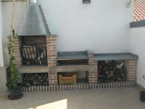 a brick fireplace with a bench and logs at Appartamento Nosside in Locri
