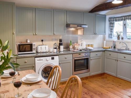 a kitchen with blue cabinets and a table with chairs at The Old Butcher's Shop in Wereham