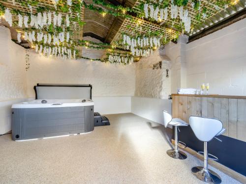 a room with a hot tub and chairs in it at The Moat House in Cudworth