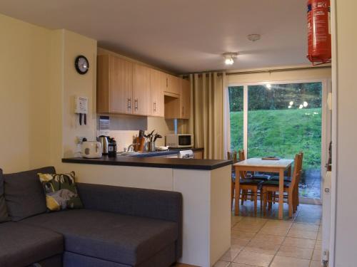a kitchen and living room with a couch and a table at Atlantic Lodge in Saint Columb Major
