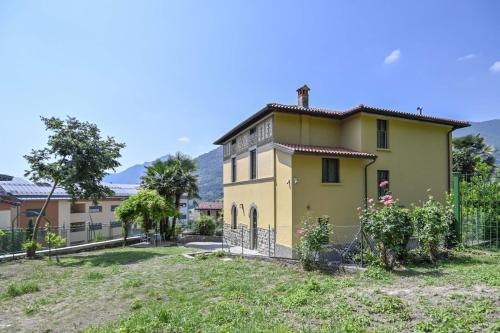 a yellow house with a fence in a yard at Villa Giovanna, Beautiful Rooms - by Host4U in Solto Collina