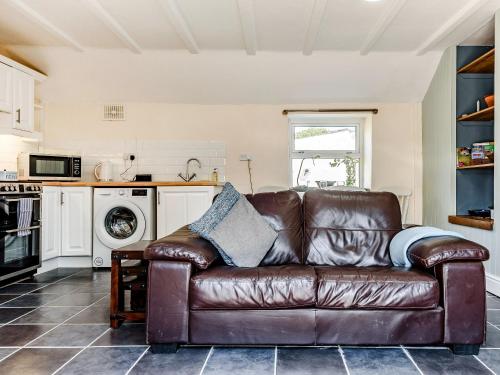 a brown leather couch in a living room at Studio Cottage in Treffynnon 