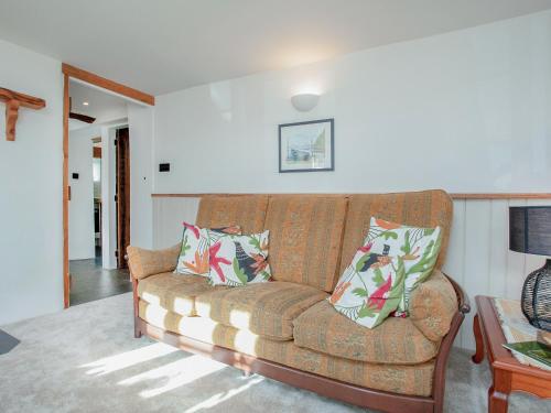 a living room with a brown couch with pillows at Welcome Cottage in Woolfardisworthy