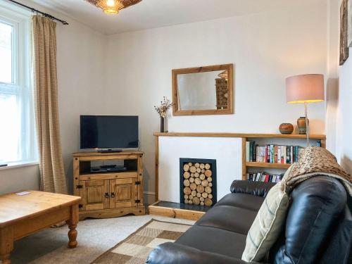 ein Wohnzimmer mit Couch und Kamin in der Unterkunft Dolphin Cottage in Braunton