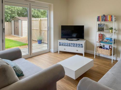 a living room with a couch and a tv at Bay Tree House in Dove Holes