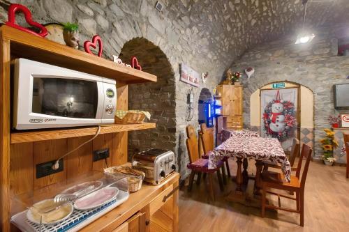 a kitchen with a counter with a microwave and a table at Arthemisia - Rhêmes-Notre-Dame in Rhêmes-Notre-Dame