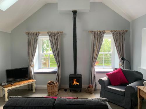 ein Wohnzimmer mit Kamin und Couch in der Unterkunft Newonstead Bothy - Cottage in Kirkharle