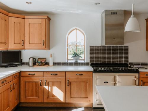 a kitchen with wooden cabinets and a white counter top at Farmhouse - Ukc6630 in Pentney