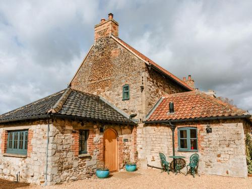 an old stone building with two chairs in front of it at Farmhouse - Ukc6630 in Pentney