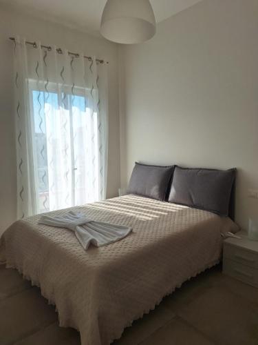 a bedroom with a large bed with a window at DGD house in Carrara