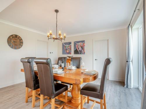 una sala da pranzo con tavolo in legno e sedie nere di Manor Farm Cottage a Hornby