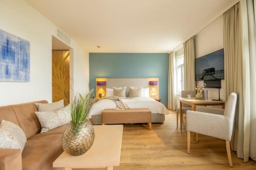 ein Hotelzimmer mit einem Bett und einer Couch in der Unterkunft Seehotel am Kaiserstrand in Lochau