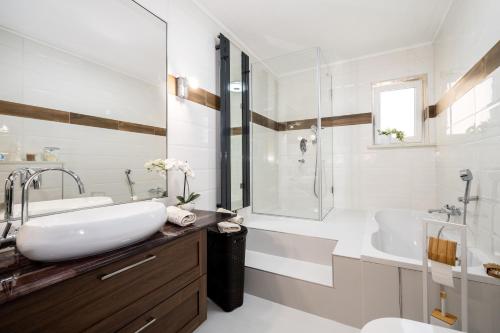 a bathroom with a sink and a tub and a toilet at Wunderschöner Neubau Bungalow Mit Privatem Pool Und Jacuzzi in Vozilići