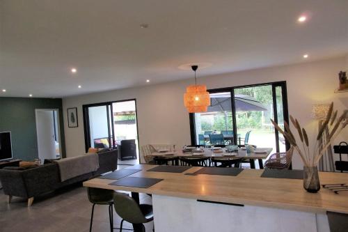 un salon avec une table et une salle à manger dans l'établissement Spacious house with garden, à Soustons