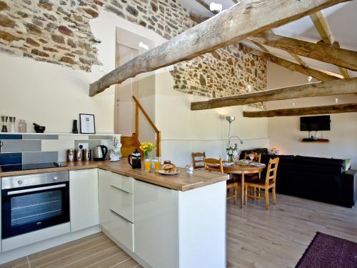 cocina con armarios blancos y comedor con mesa en Blackbird Cottage, en Kings Nympton