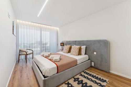 a bedroom with a large bed with a large window at GuestReady - Beautiful getaway in Gaia in Vila Nova de Gaia
