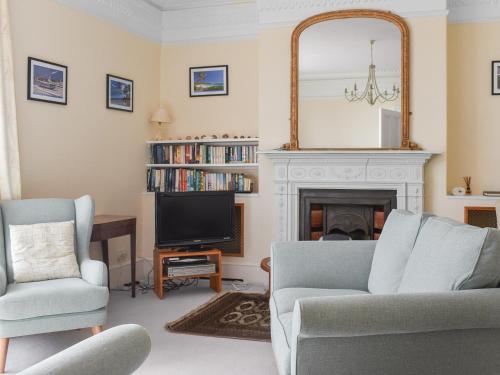 a living room with a fireplace and a mirror at Bessborough in Saint Mawes
