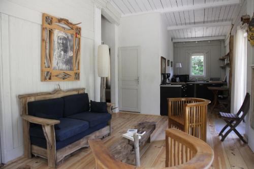 un salon avec un canapé bleu et des chaises dans l'établissement Cabane de la leque, à Fontvieille